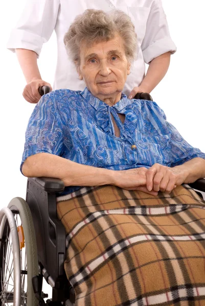 Jovem enfermeira incentivando mulher idosa em cadeira de rodas — Fotografia de Stock