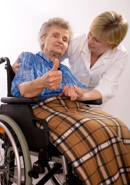 Εργαζόμενος υγειονομική περίθαλψη και η ηλικιωμένη γυναίκα σε αναπηρική καρέκλα — Φωτογραφία Αρχείου