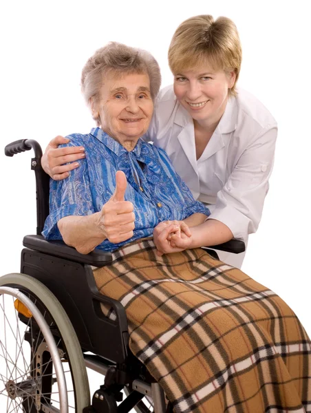 Pracowników służby zdrowia i starsza kobieta na wózku inwalidzkim — Zdjęcie stockowe