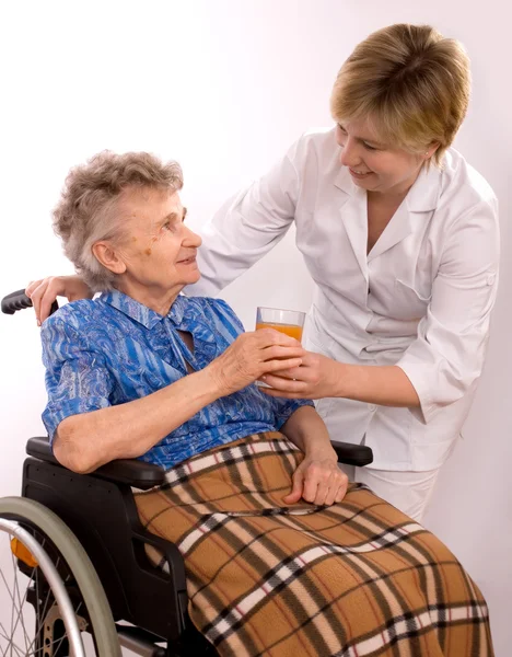 Młoda pielęgniarka zachęcanie starszych kobieta na wózku inwalidzkim — Zdjęcie stockowe