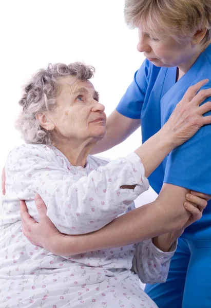 Enfermeira ajuda a mulher idosa a se levantar — Fotografia de Stock