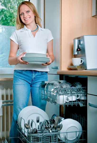 加载的菜放到洗碗机的女人 — 图库照片
