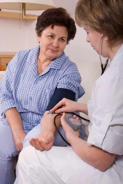 Doctor measuring the blood pressure of a patient — Stock Photo, Image
