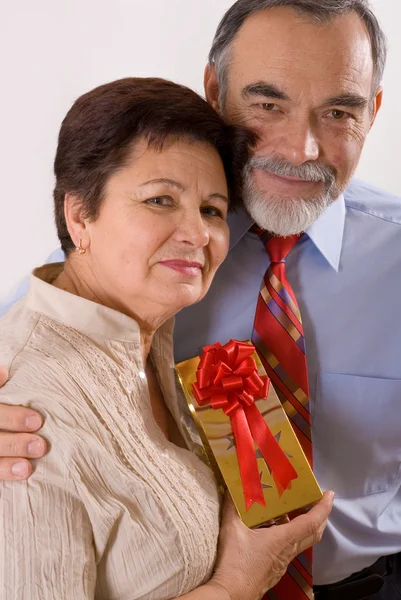 Elderly happy couple with gift — Stock Photo, Image