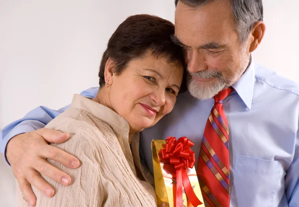 Starší šťastnému páru s dárkem — Stock fotografie