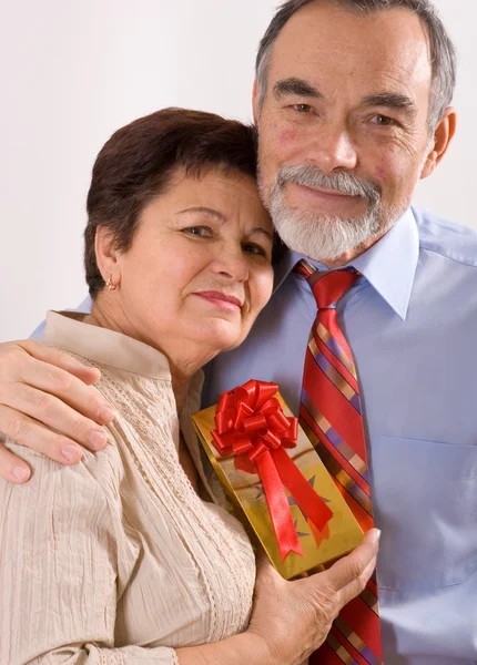 Osoby w podeszłym wieku szczęśliwa para z prezentem — Zdjęcie stockowe