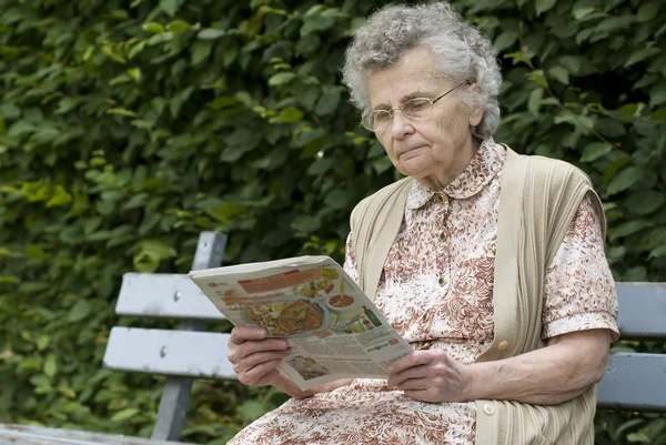 Alte Frau liest Zeitung — Stockfoto
