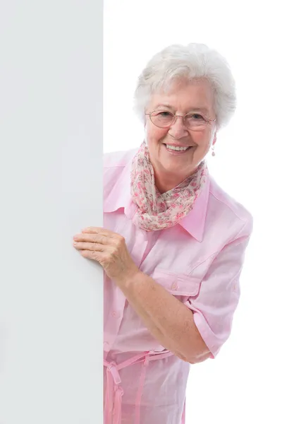 Elderly woman holding an empty white billboard — Stock Photo, Image
