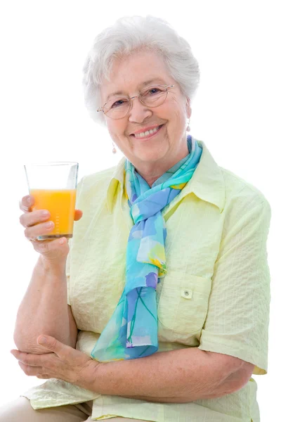 Mulher sênior desfrutando de um copo de suco de laranja — Fotografia de Stock