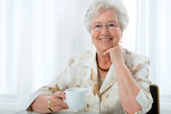 Ανώτερος γυναίκα απολαμβάνοντας ένα φλιτζάνι τσάι — Φωτογραφία Αρχείου
