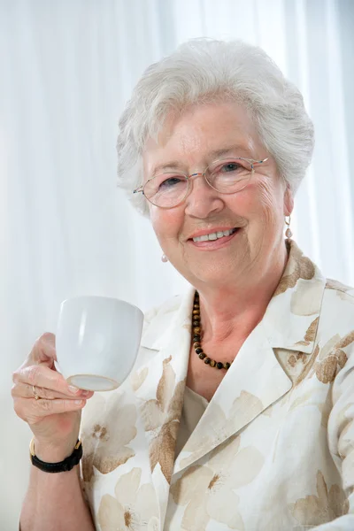 Äldre kvinna njuter av en kopp te — Stockfoto