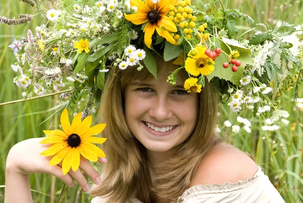 Chica con corona de flores en el prado —  Fotos de Stock
