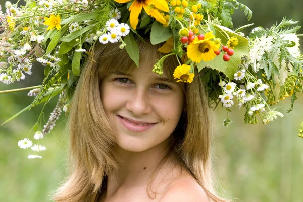 Menina com coroa de flores no prado — Fotografia de Stock