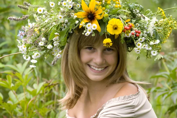 Chica con corona de flores en el prado — Foto de Stock