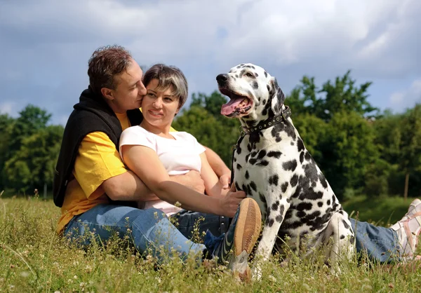 Loving couple with a Dalmatian outdoors — Stock Photo, Image