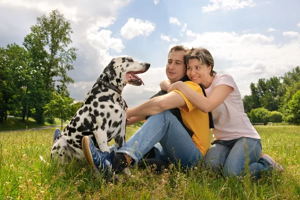 Loving couple with a Dalmatian outdoors — Stock Photo, Image