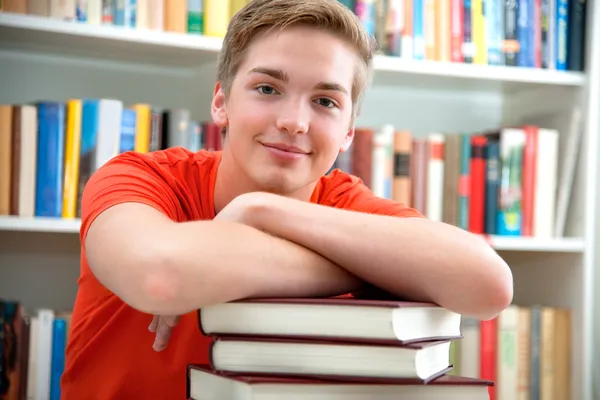 Νεαρός φοιτητής σε μια βιβλιοθήκη — Φωτογραφία Αρχείου