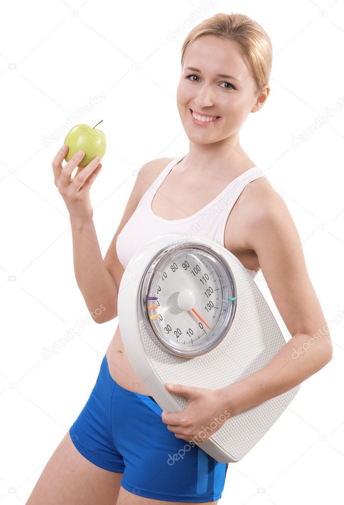 A young woman holding a weight scale and an apple