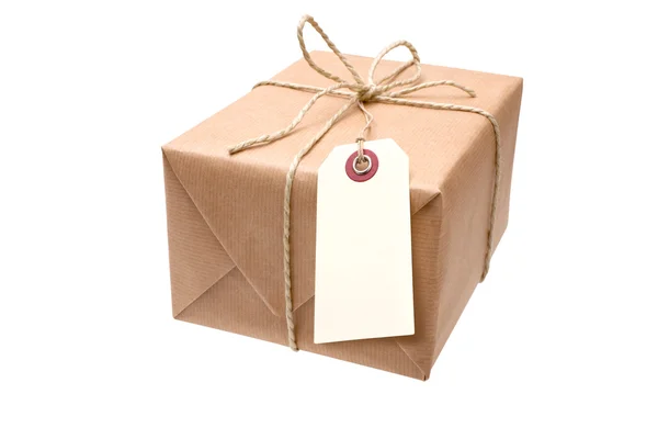 Brown paper parcel with a tag — Stock Photo, Image