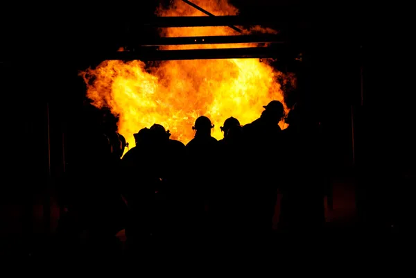 Brandmän bekämpa eld Stockbild