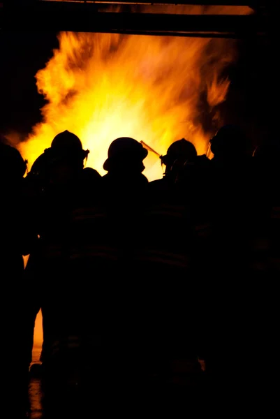 Feuerwehrleute bei einem Brand Stockbild