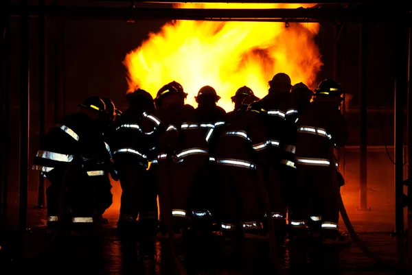 Feuerwehr bekämpft Brand Stockbild