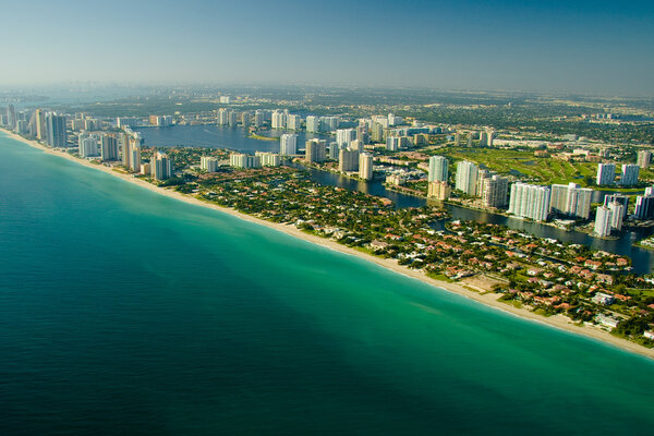 Aerial view of the seashore in Miami show deep green and blue waters