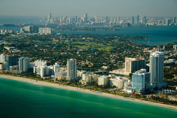 Aerial view of the seashore in Miami show deep green and blue waters