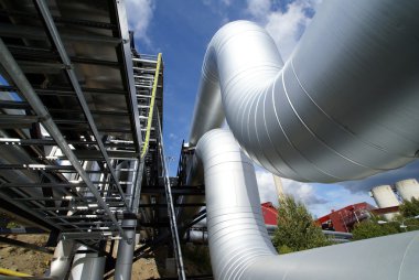 Industrial pipelines on pipe-bridge against blue sky clipart