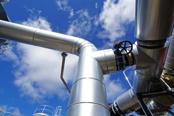 Industrial piping and valves against blue sky Stock Photo