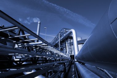 Industrial pipelines on pipe-bridge against sky in blue tone clipart