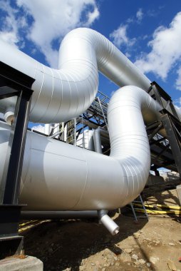 Industrial pipelines on pipe-bridge against blue sky clipart