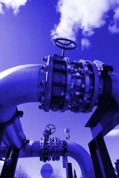 Tubos, parafusos, válvulas contra o céu azul em tom azul — Fotografia de Stock
