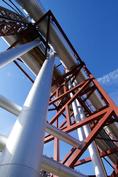 Промышленные трубопроводы на трубном мосту против голубого неба — стоковое фото