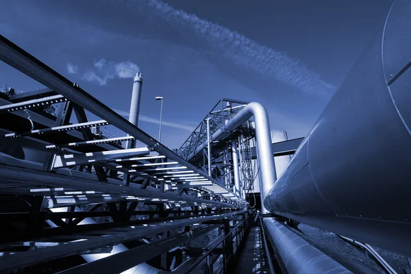 Промышленные трубопроводы на трубном мосту против неба в синем тоне — стоковое фото