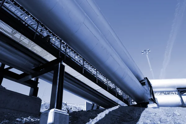 Промислові трубопроводи на трубопроводі-мосту на фоні блакитного неба — стокове фото