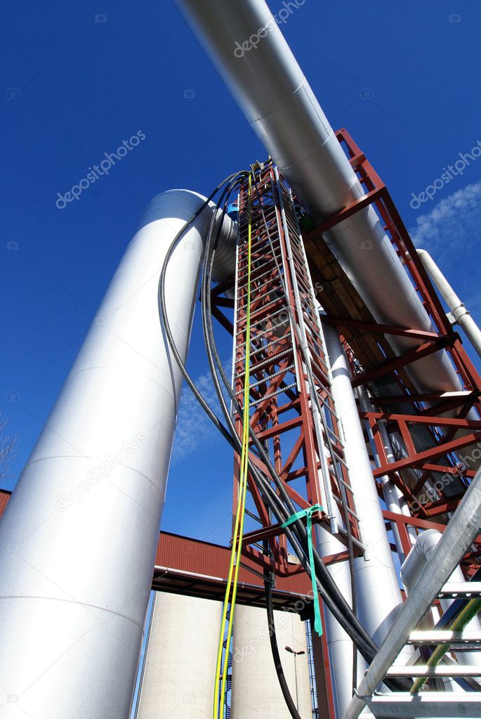 Industrial pipelines on pipe-bridge against blue sky