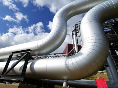 Industrial pipelines on pipe-bridge against blue sky clipart