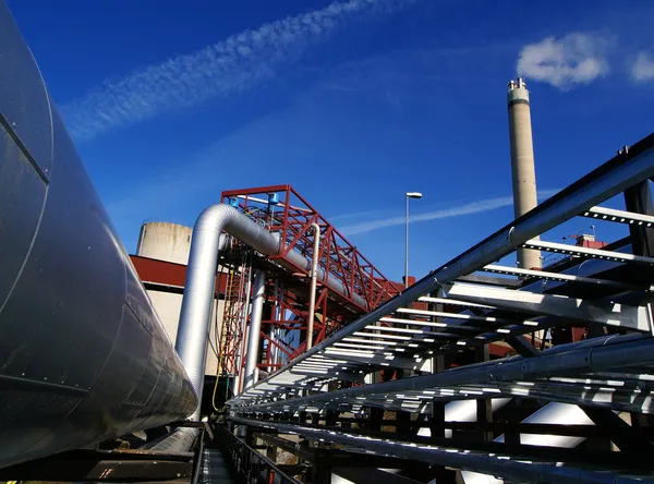 Zona industrial, oleodutos de aço e chaminé no céu azul — Fotografia de Stock