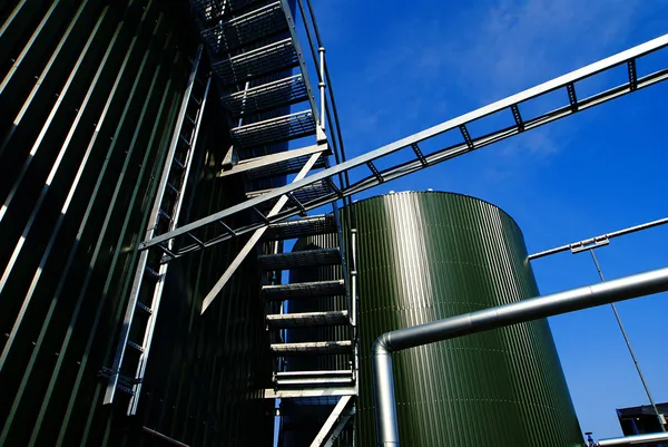 Zona industrial, dutos de aço e tanques contra o céu azul — Fotografia de Stock