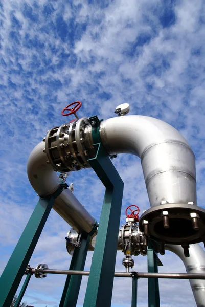 Промышленная зона, стальные трубопроводы и клапаны против голубого неба — стоковое фото