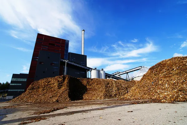 Biokraftverk med lagring av träbränsle mot blå himmel — Stockfoto