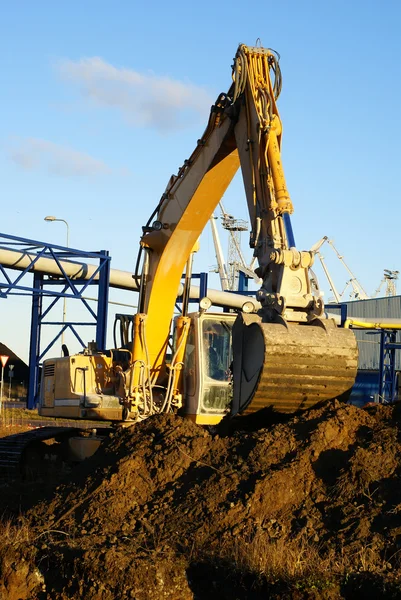 Hydraulic excavator at work. Shovel bucket against blue sky — Stock Photo, Image