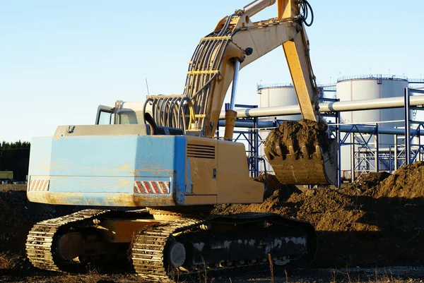 Excavadora hidráulica en el trabajo. Cubo de pala contra el cielo azul —  Fotos de Stock