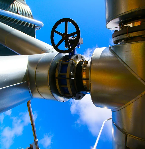 Ipari övezet, acélvezetékek és szelepek a kék ég ellen — Stock Fotó