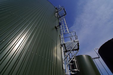 Industrial pipelines and tanks against blue sky clipart