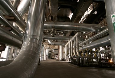 Pipes, tubes, machinery and steam turbine at a power plant clipart