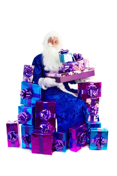 Santa claus siedzi z mnóstwem prezentów — Zdjęcie stockowe