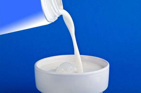 Une tasse de lait sur fond bleu — Photo