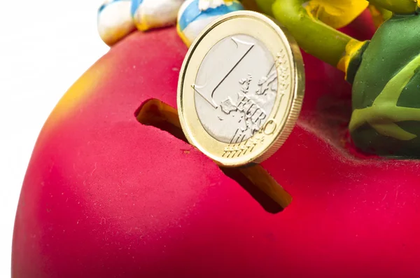 Красная копилка с монетой евро — стоковое фото